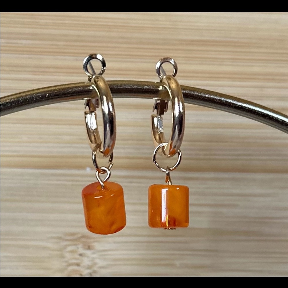 Gold hoop earrings with orange dangle bead
